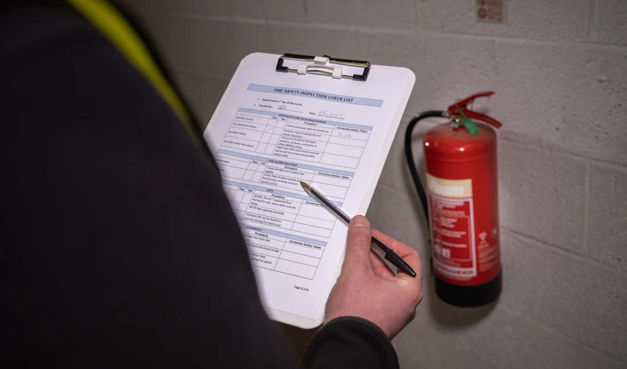 Person inspecting fire extinguisher checklist